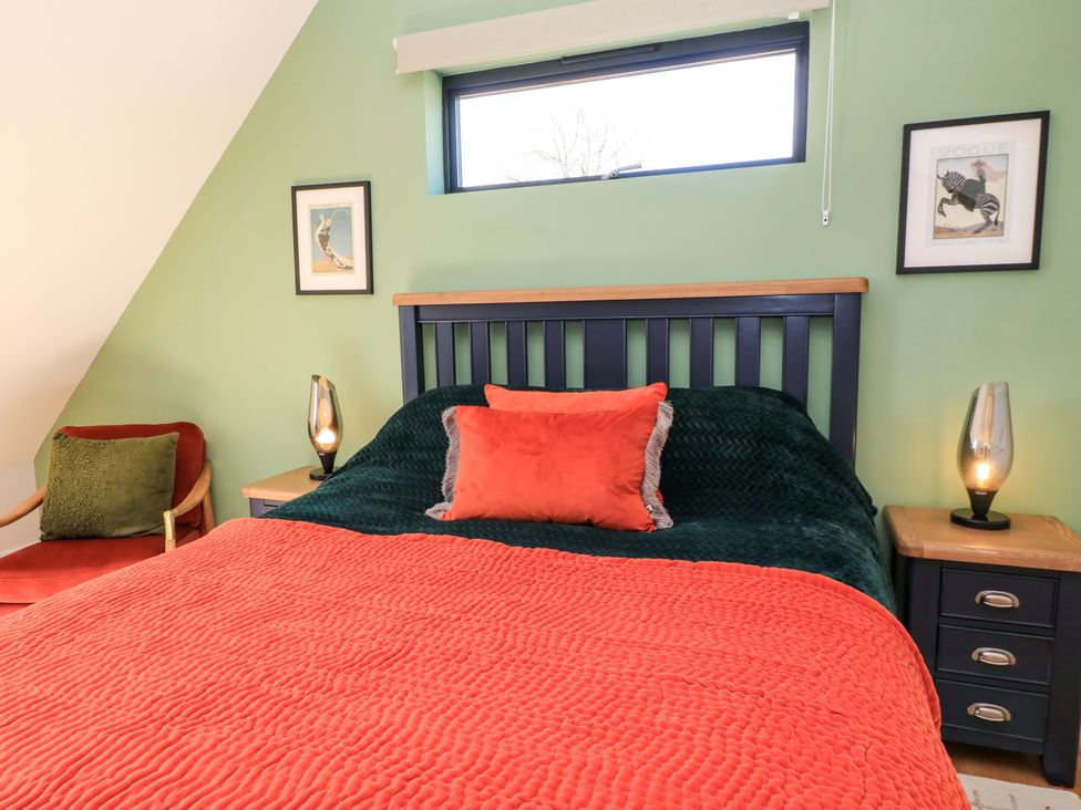 A bedroom with a bed and artwork on the wall at The Old Dairy in Cotleigh near Honiton