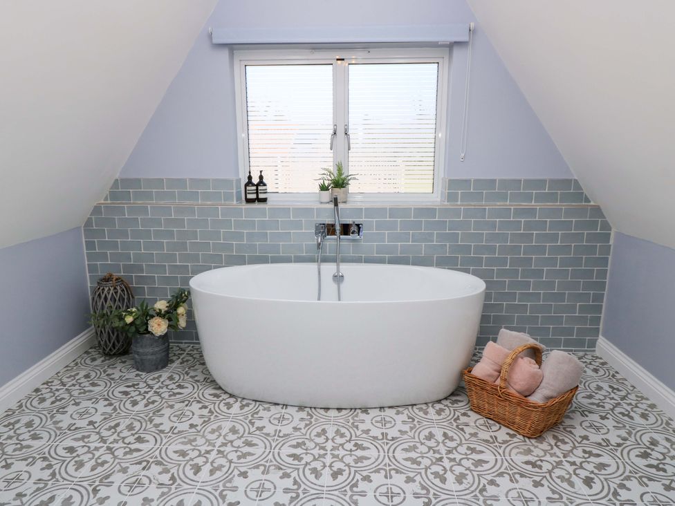 A bathroom with a bathtub and sink at The Old Dairy in Cotleigh near Honiton