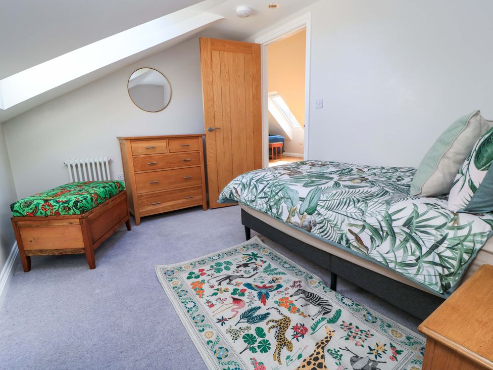 A bedroom with a bed and dresser at The Old Dairy Cotleigh near Honiton