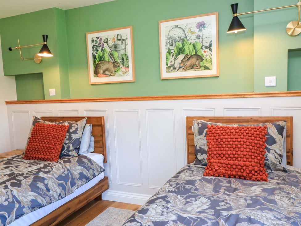 A bedroom with two beds and wall art at The Old Dairy Cotleigh near Honiton