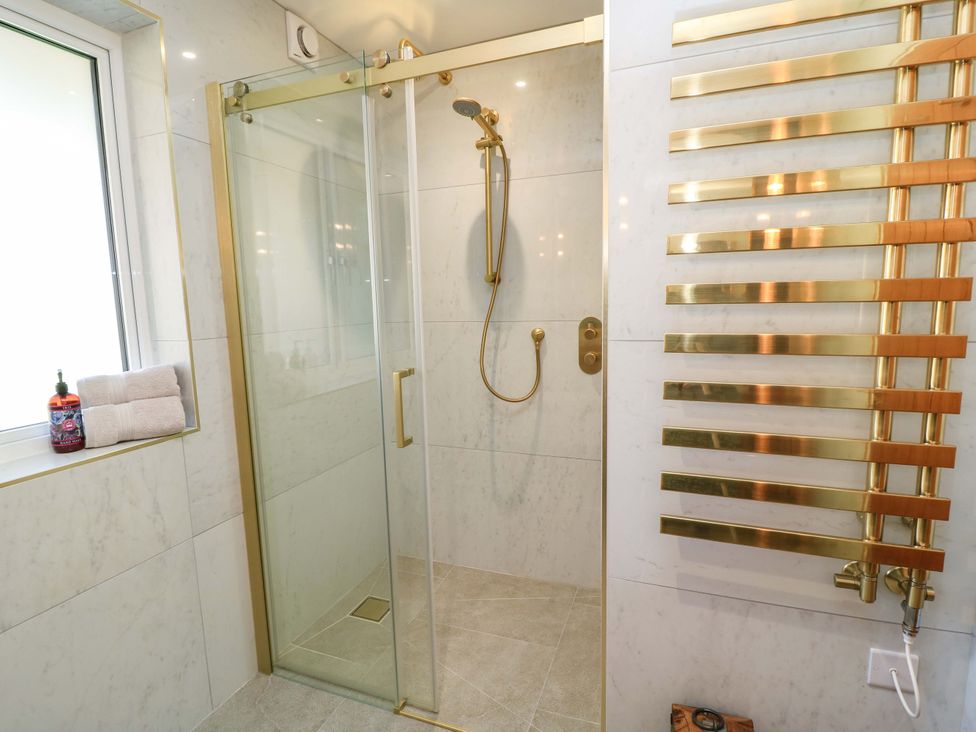 A bathroom with a shower and towels at The Old Dairy Cotleigh near Honiton
