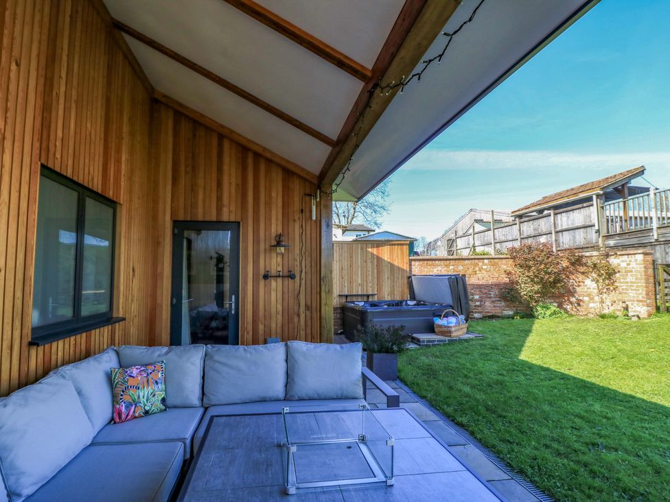 An outdoor area with a couch and table at The Old Dairy Cotleigh near Honiton