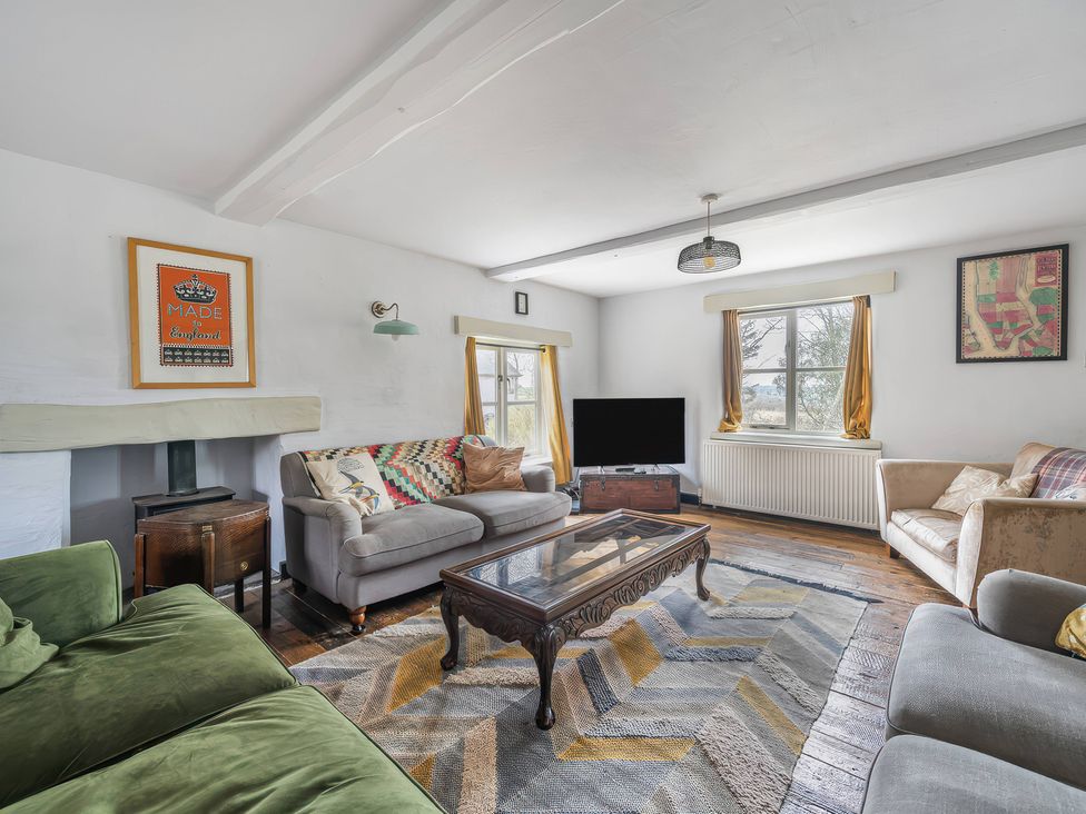 A living room with a coffee table and television at Spring Park Farmhouse Launceston