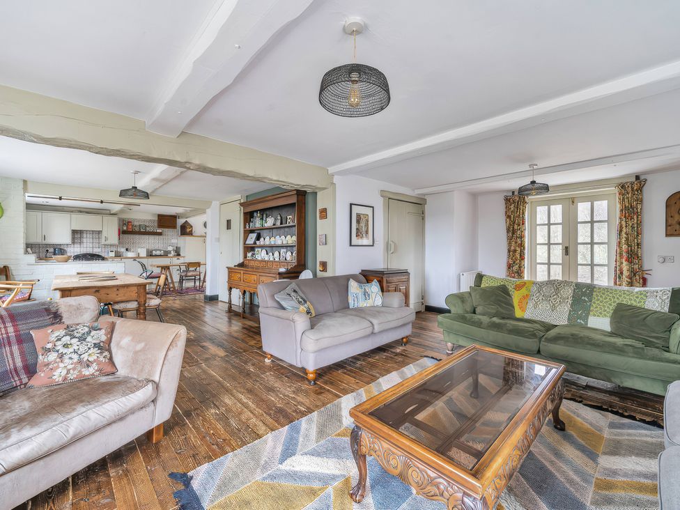 A living room with sofas, a coffee table and a dining table at Spring Park Farmhouse in Launceston