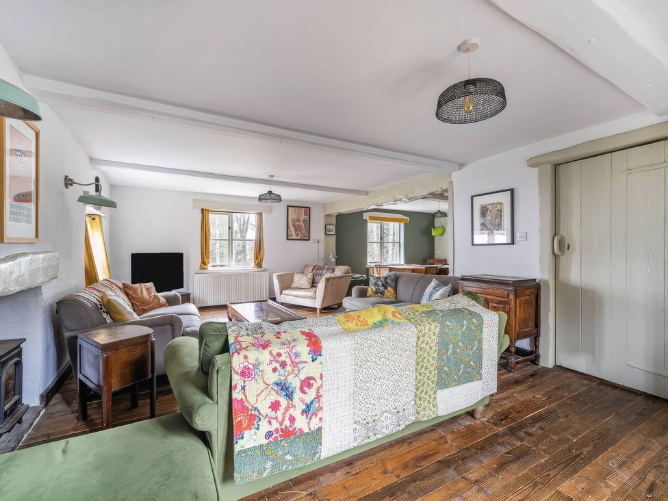 A living room with a sofa, armchair, and table at Spring Park Farmhouse in Launceston