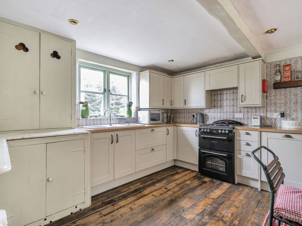 A kitchen with cabinets, a sink, oven, and microwave at Spring Park Farmhouse in Launceston