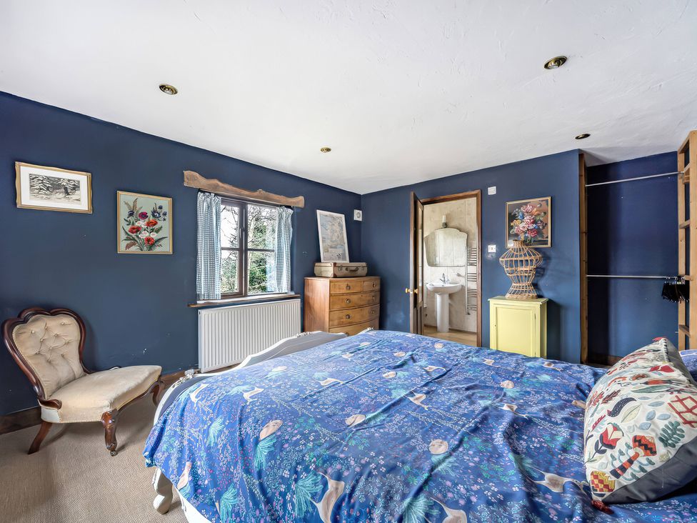 A bedroom with a bed and armchair at Spring Park Farmhouse in Launceston