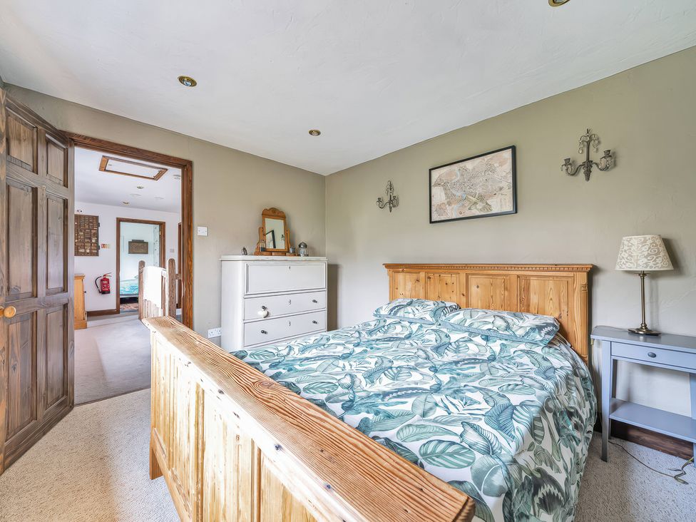 A bedroom with a bed, dresser, and lamp at Spring Park Farmhouse in Launceston