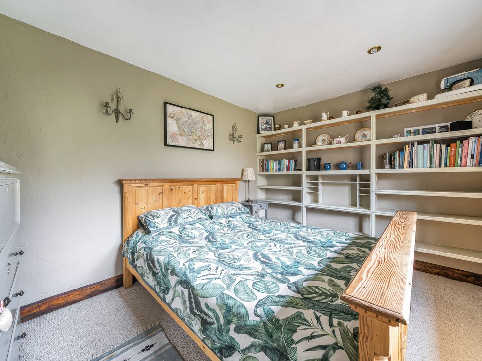 A bedroom with a bed and bookshelf at Spring Park Farmhouse in Launceston