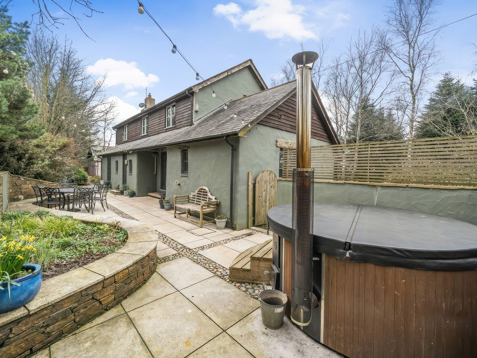 A garden with a hot tub and table at Spring Park Farmhouse in Launceston