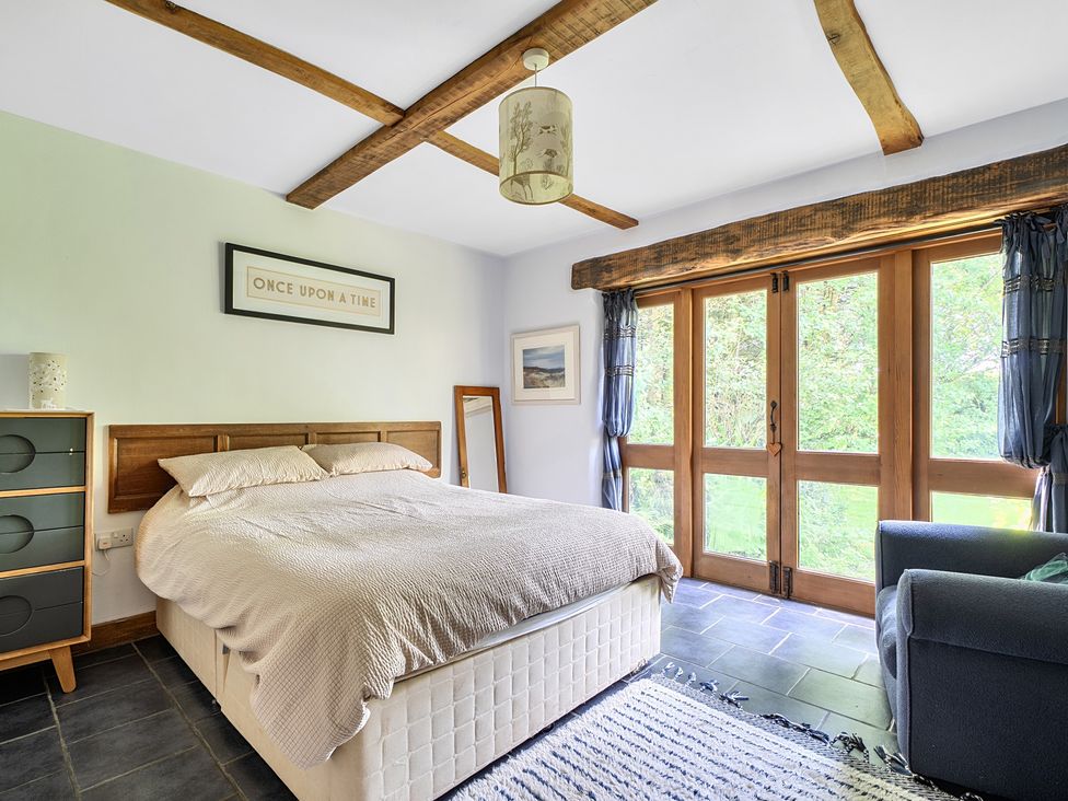 A bedroom with a bed and wardrobe at Woodcutters in Rezare near Launceston