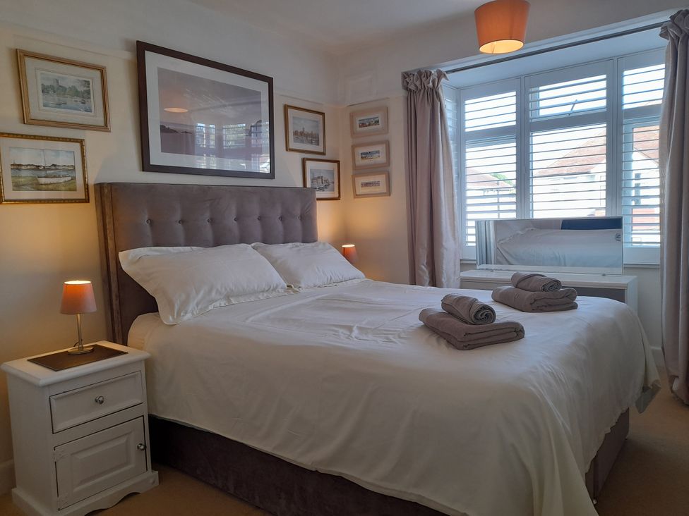 A bedroom with a bed, nightstand, and wall art at 32 Cranleigh Close Tuckton