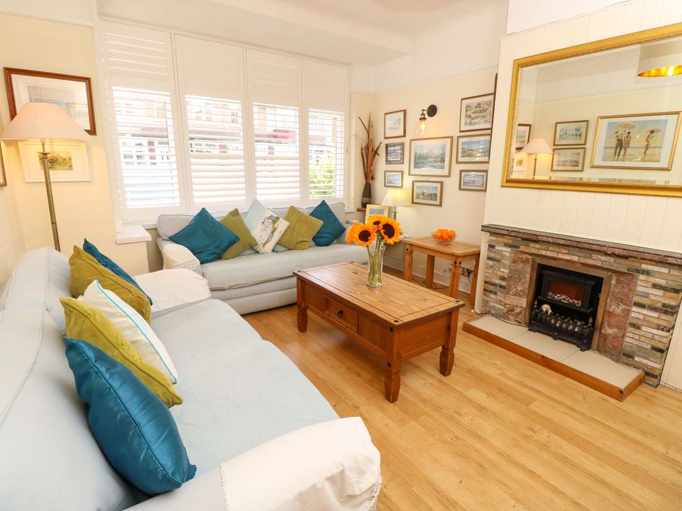 A living room with sofas, a coffee table, and a fireplace at 32 Cranleigh Close in Tuckton