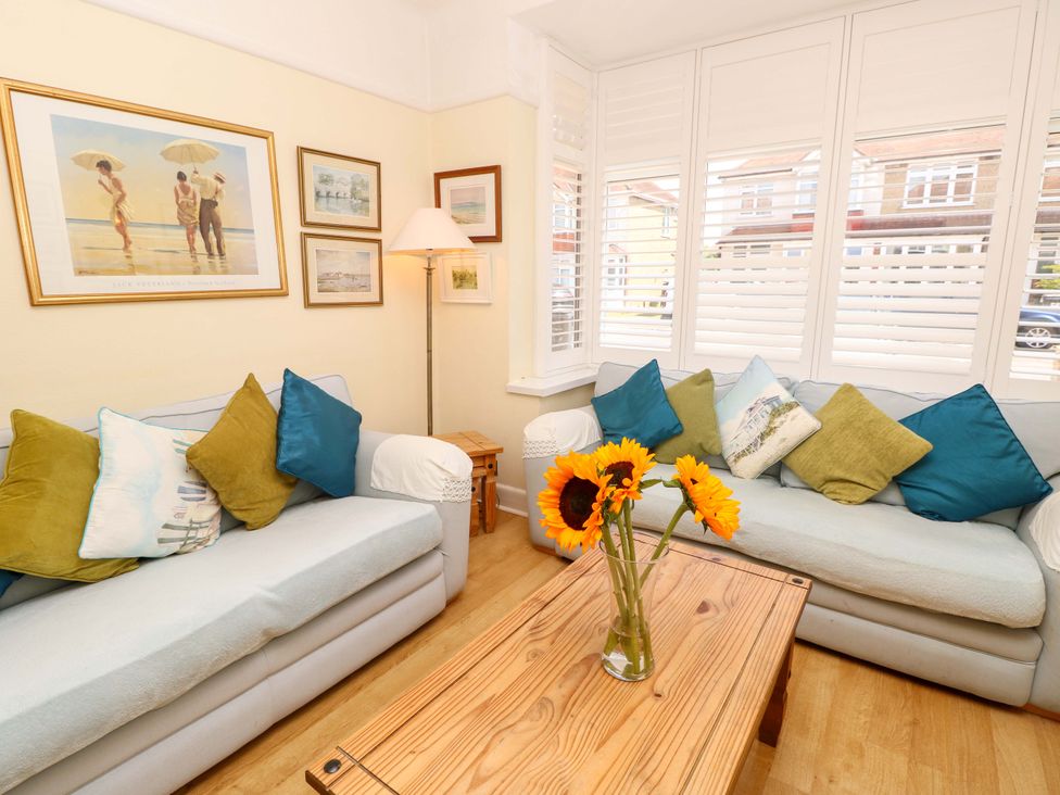 A living room with sofas and wall art at 32 Cranleigh Close Tuckton