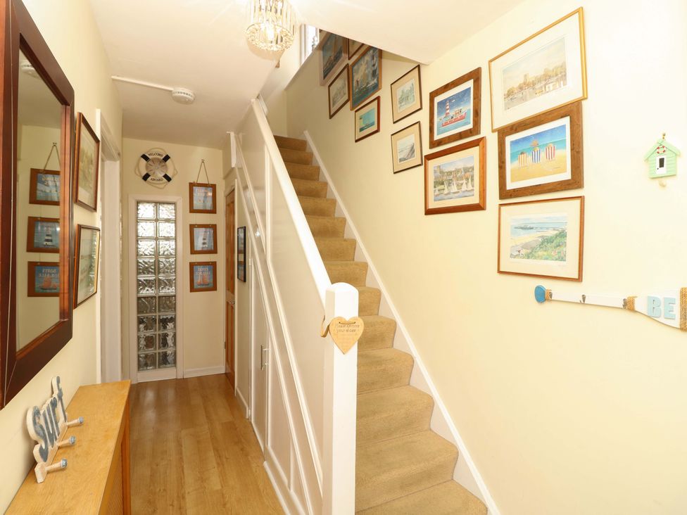 A hallway with a staircase and wall art at 32 Cranleigh Close Tuckton