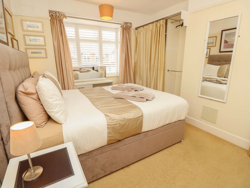 A bedroom with a bed and mirror at 32 Cranleigh Close Tuckton