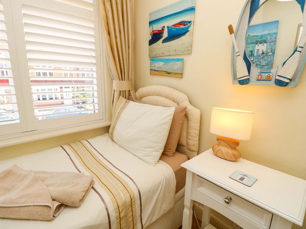 A bedroom with a bed and a lamp at 32 Cranleigh Close Tuckton