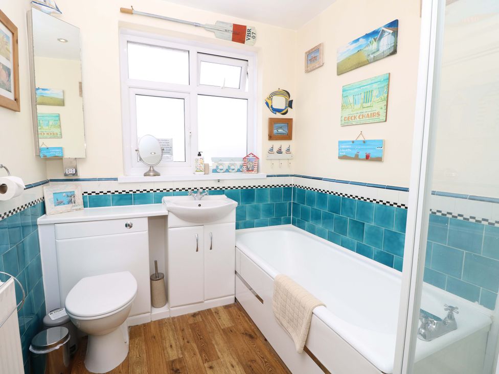 A bathroom with a bathtub and sink at 32 Cranleigh Close Tuckton