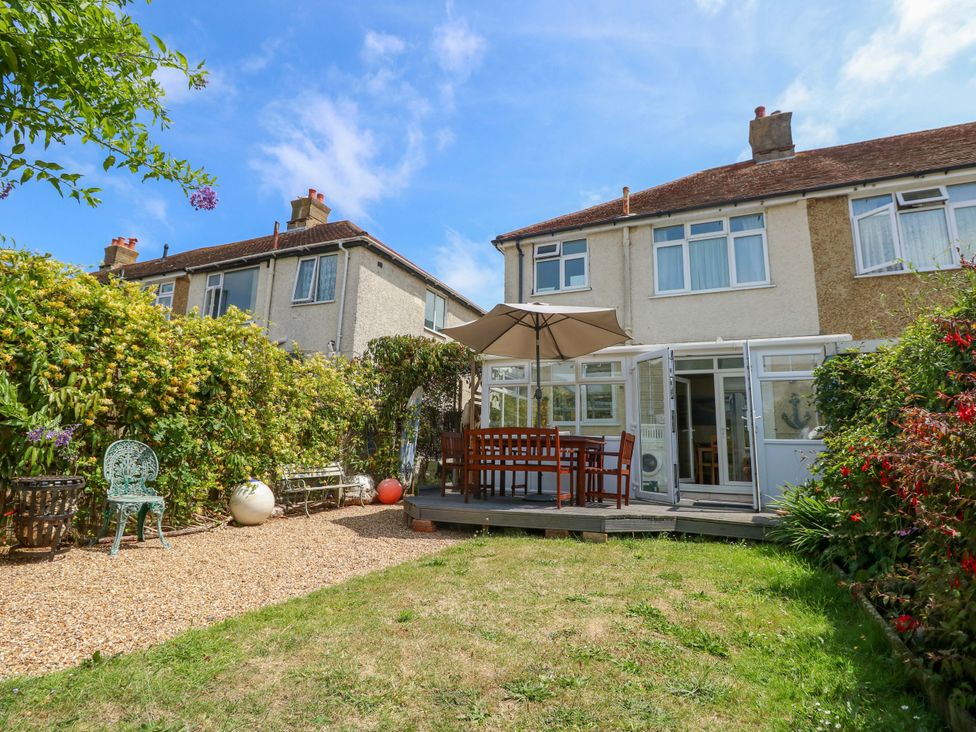 A garden with a table and chairs under an umbrella at 32 Cranleigh Close Tuckton