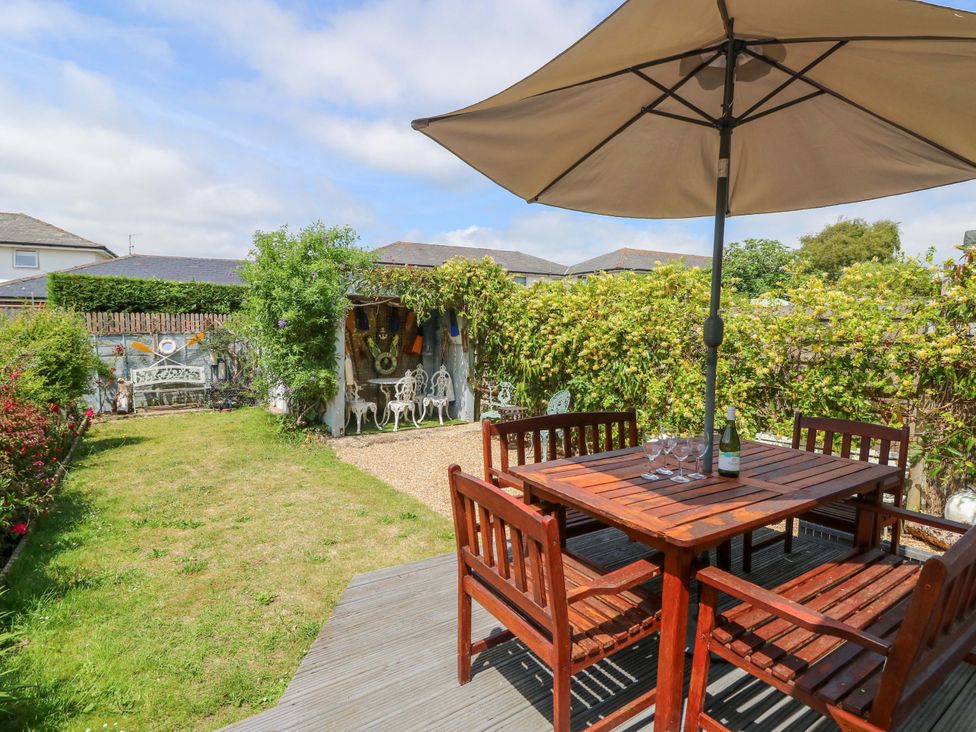 A garden with a table and chairs under an umbrella at 32 Cranleigh Close Tuckton