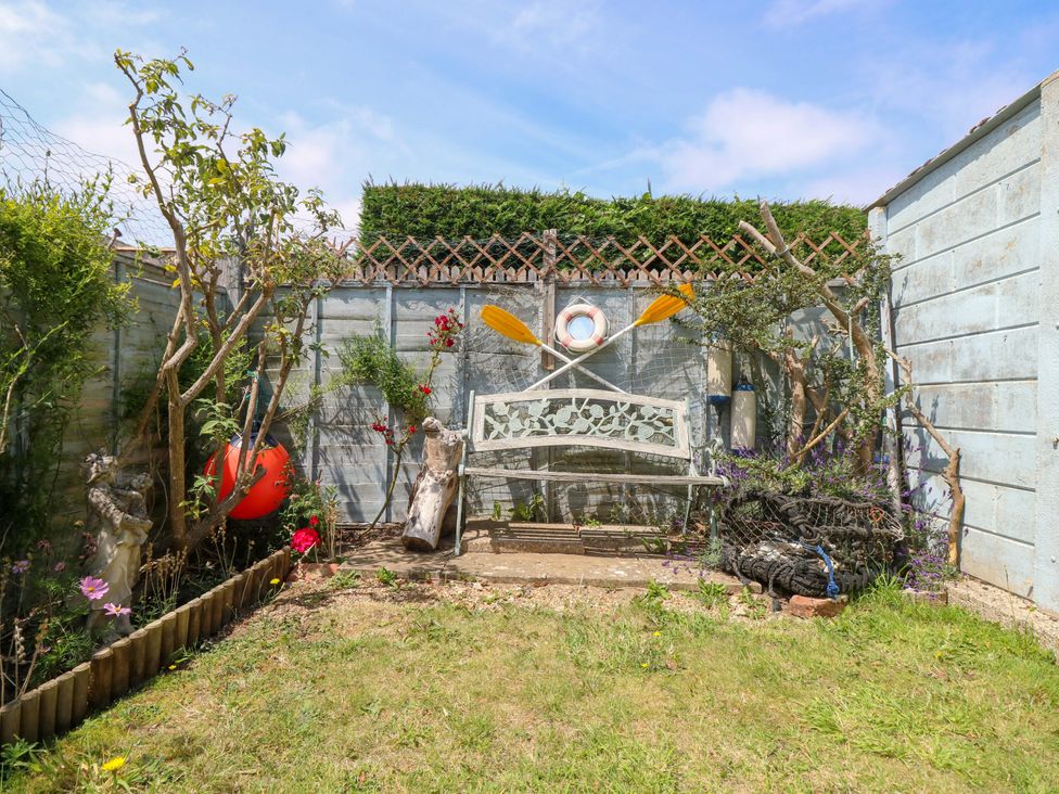 A garden with a bench and decorative items at 32 Cranleigh Close Tuckton