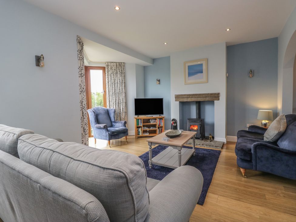 A living room with a television and fireplace at Langtree in Arnside