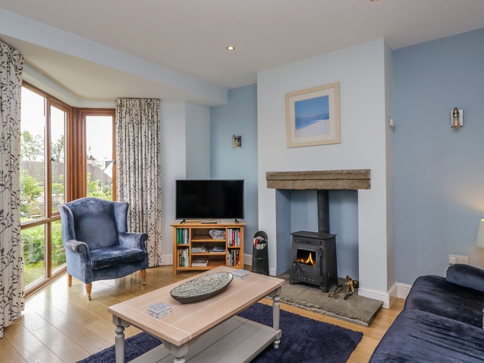 A living room with an armchair and fireplace at Langtree in Arnside