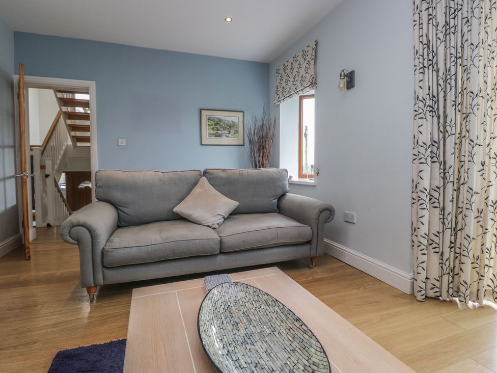 A living room with a sofa and table at Langtree in Arnside