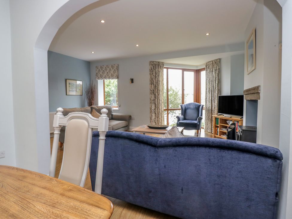 A living room with a sofa, armchair, and television at Langtree in Arnside