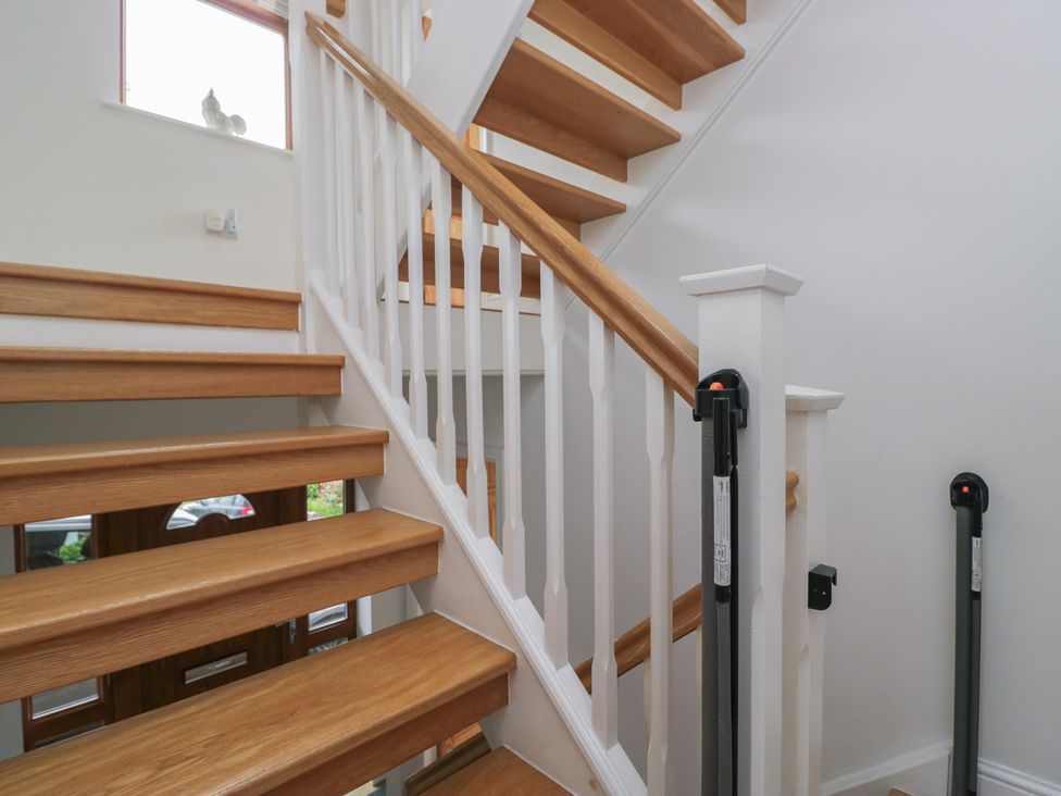 A staircase with wooden steps and banister at Langtree in Arnside