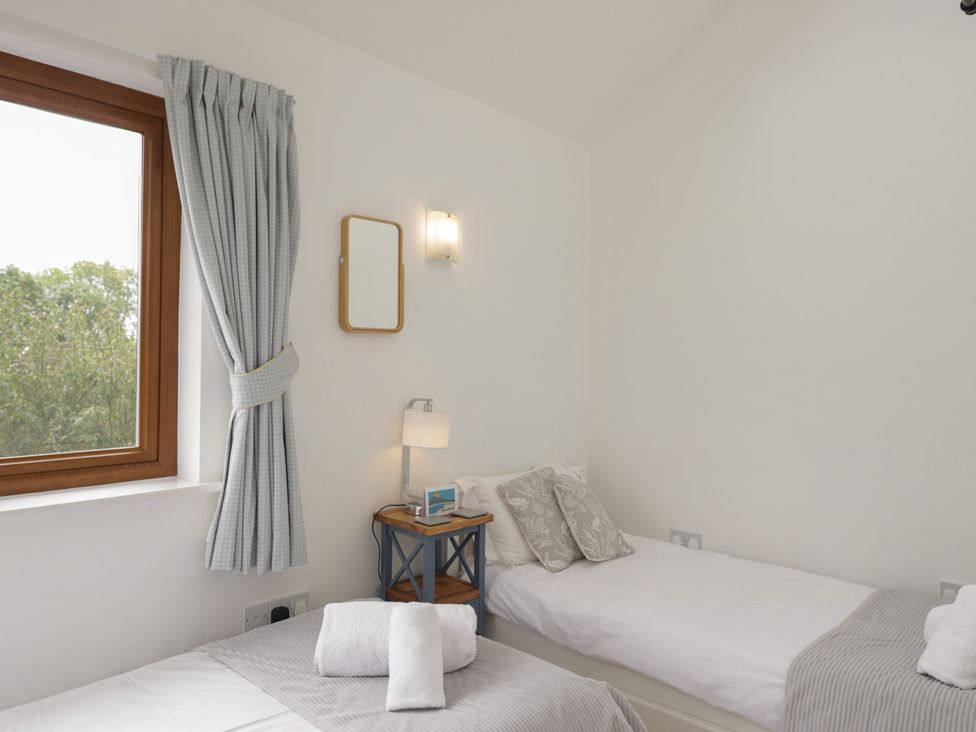 A bedroom with two beds and a window at Langtree in Arnside