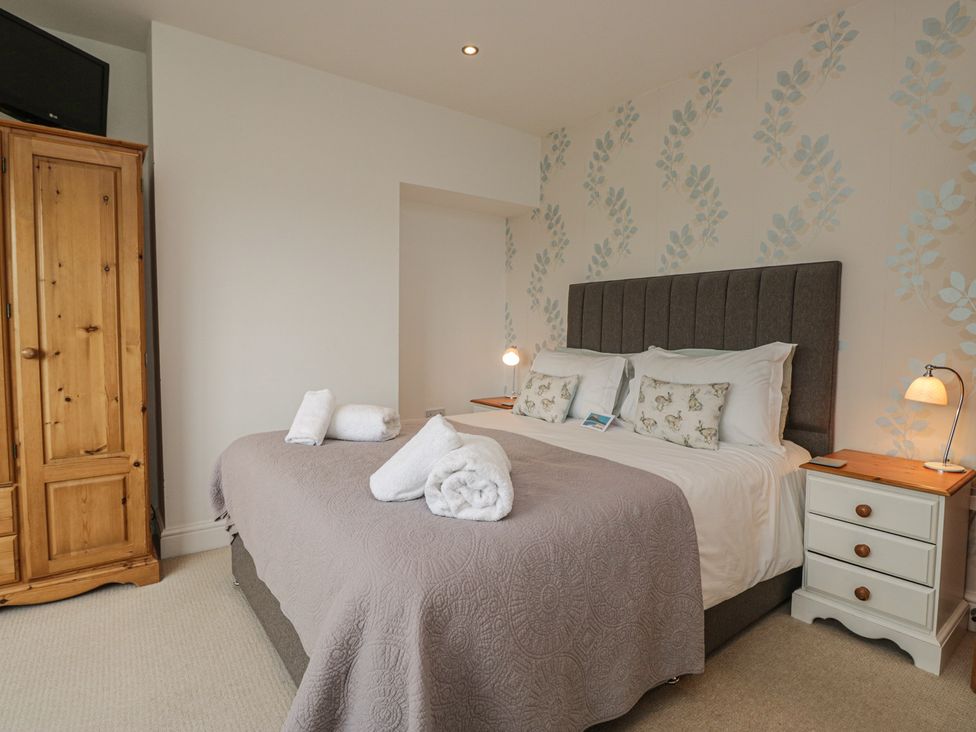 A bedroom with a bed and wardrobe at Langtree in Arnside