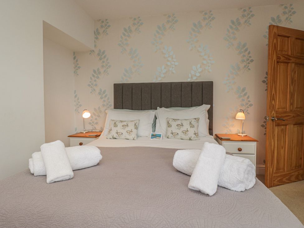 A bedroom with a bed and towels at Langtree in Arnside