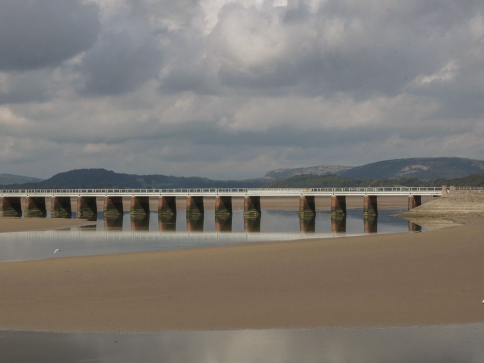 A bridge over water with sandy shore at Langtree in Arnside