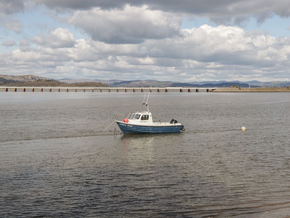 A boat on water with a pier in the background at Langtree in Arnside