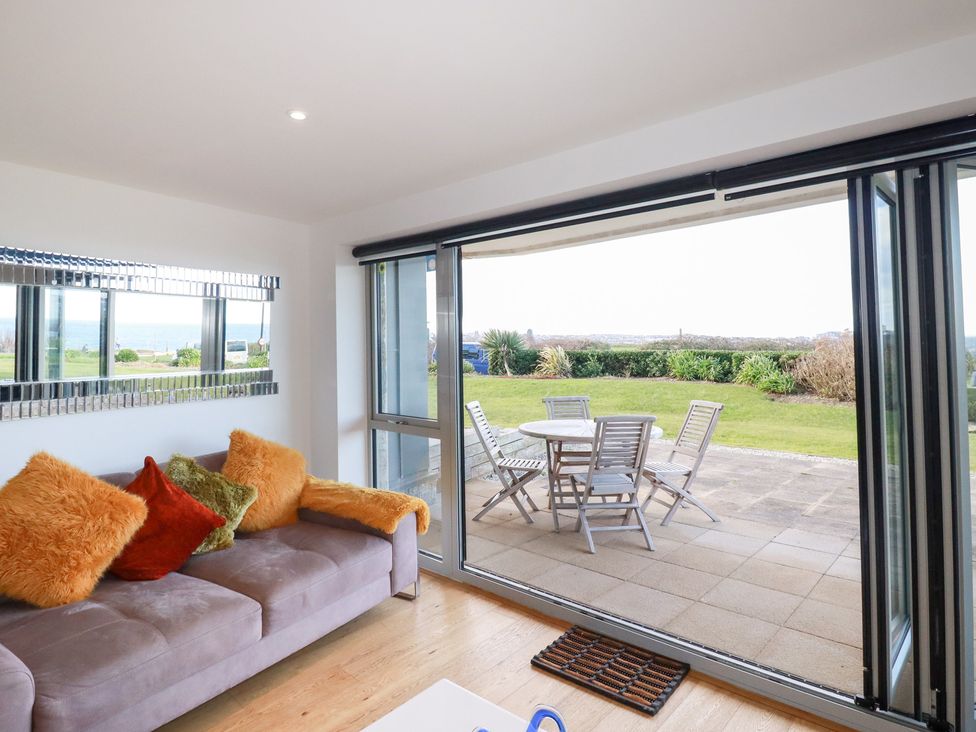 A living room with a sofa and glass sliding doors at Apartment no.21 in Newquay