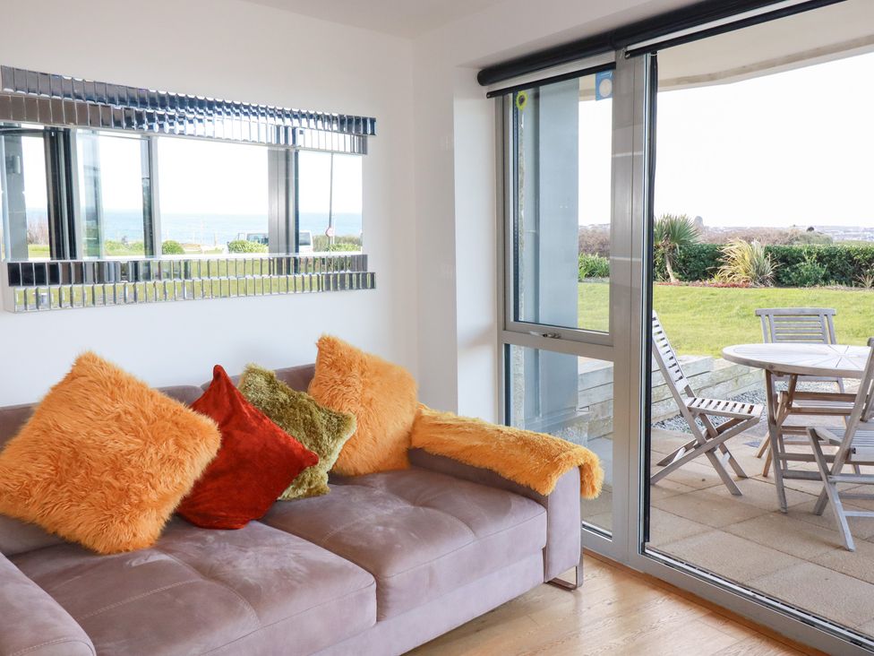 A living room featuring a sofa and window overlooking the garden at Apartment no.21 in Newquay