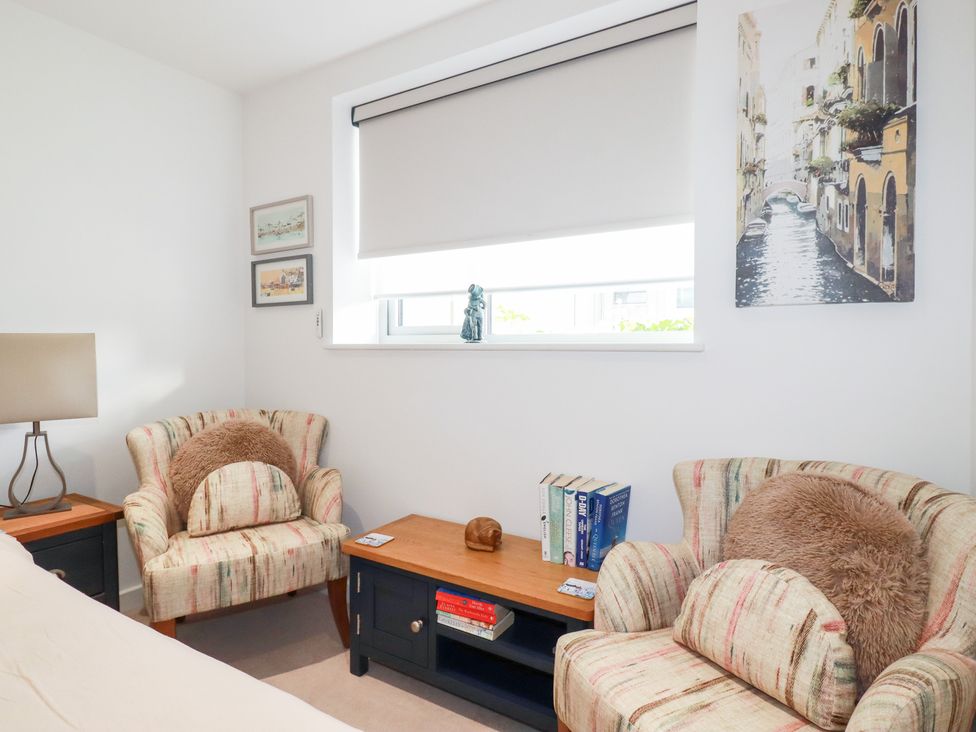 A living room with chairs and books in Apartment no.21 Newquay