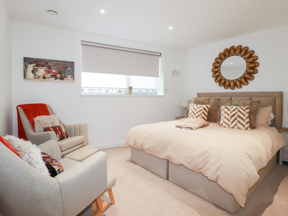 A bedroom with a bed and armchairs at Apartment no.21 Newquay