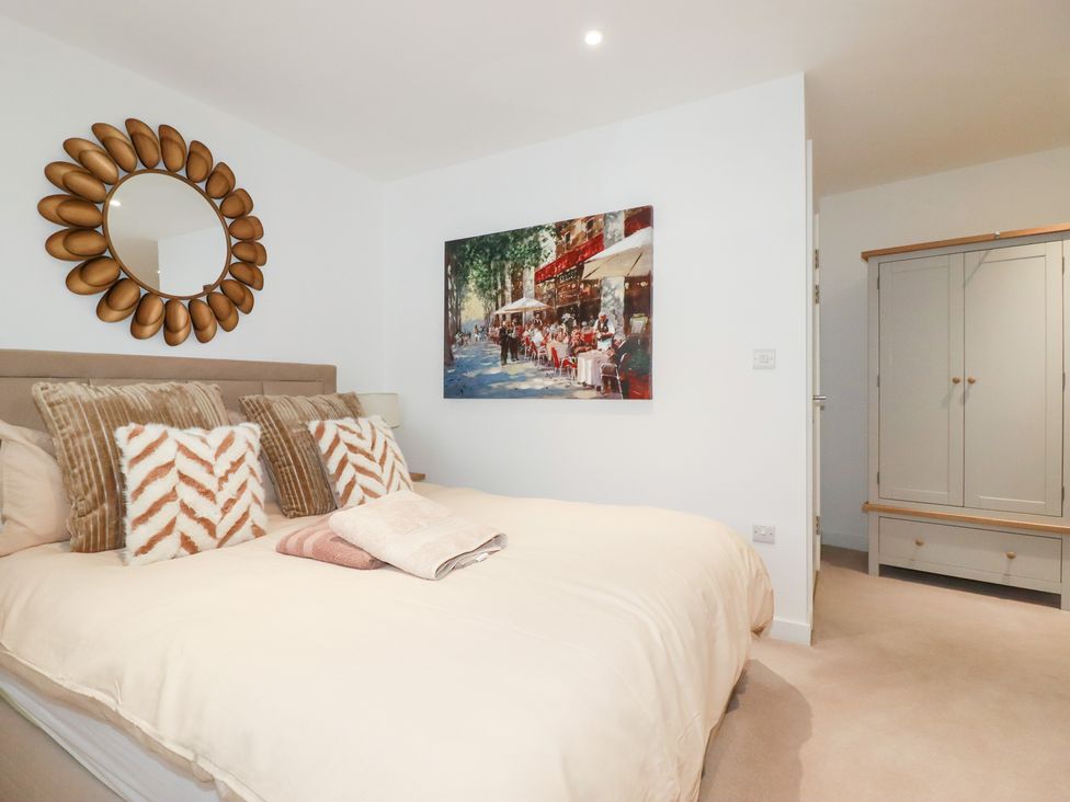 A bedroom with a bed and wardrobe at Apartment no.21 in Newquay