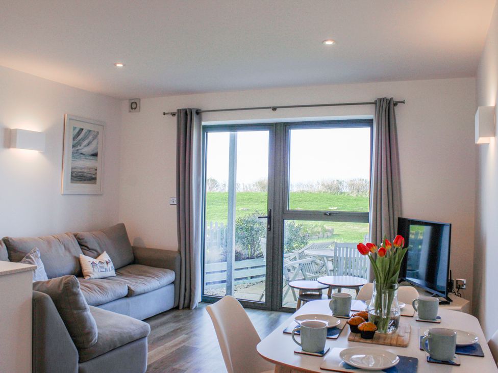 A living room with a sofa and dining area at 4 Ocean Reach in Bolberry