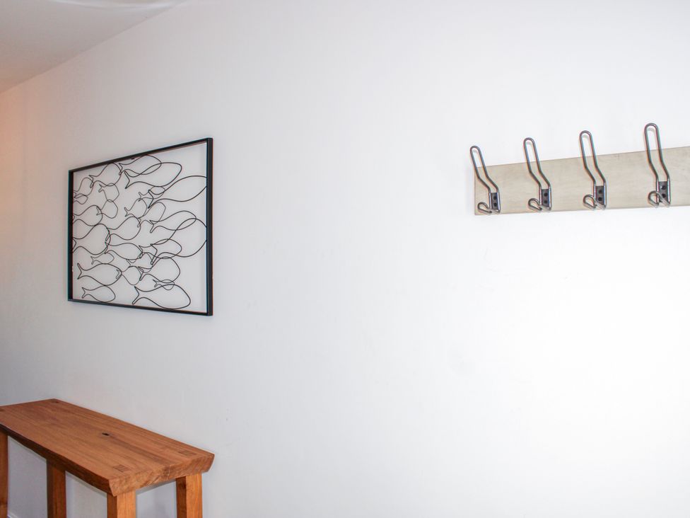 A hallway with wall art and coat hooks at 4 Ocean Reach, Bolberry