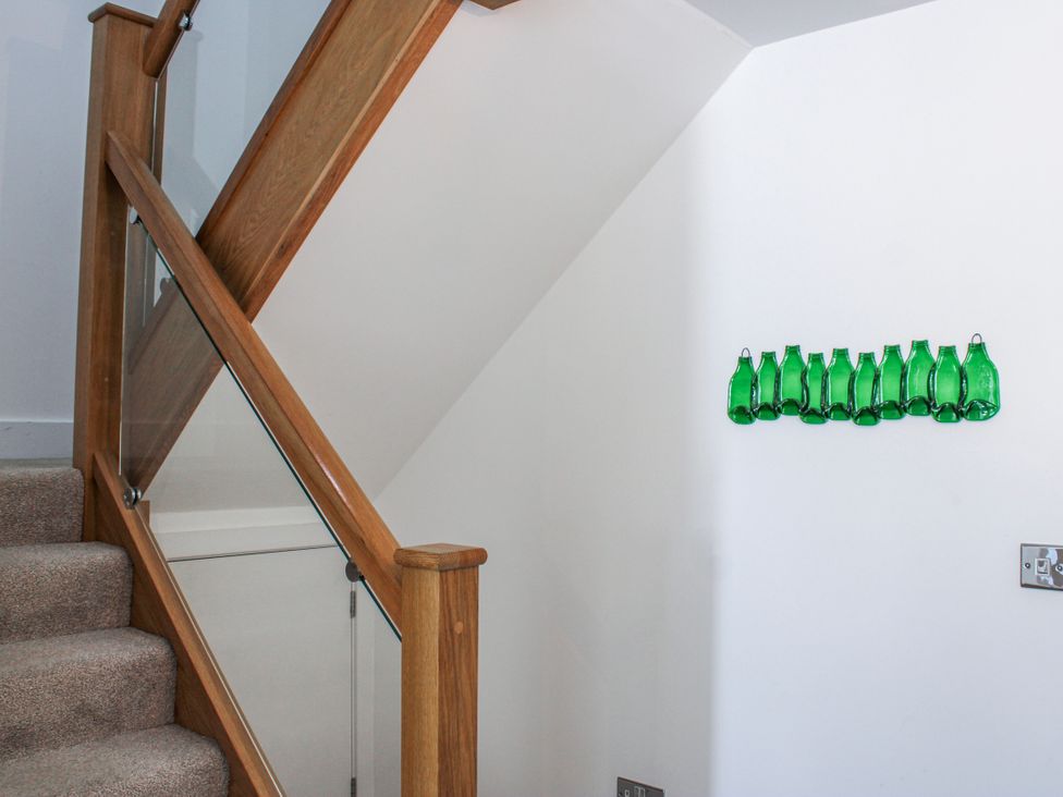 A staircase with glass bottles on the wall at 4 Ocean Reach in Bolberry