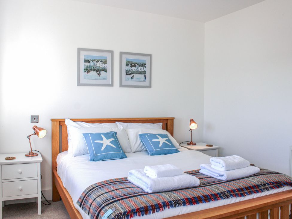 A bedroom with a bed and side tables at 4 Ocean Reach Bolberry