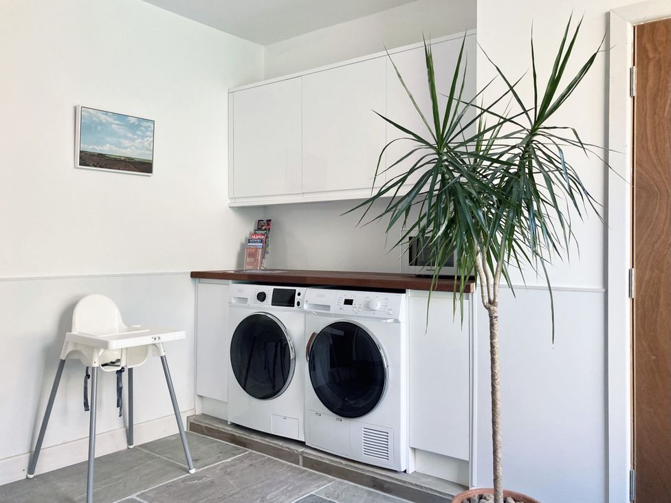 A laundry room with a washing machine and dryer at The Old Riverside School House Apt 5 Hebden Bridge