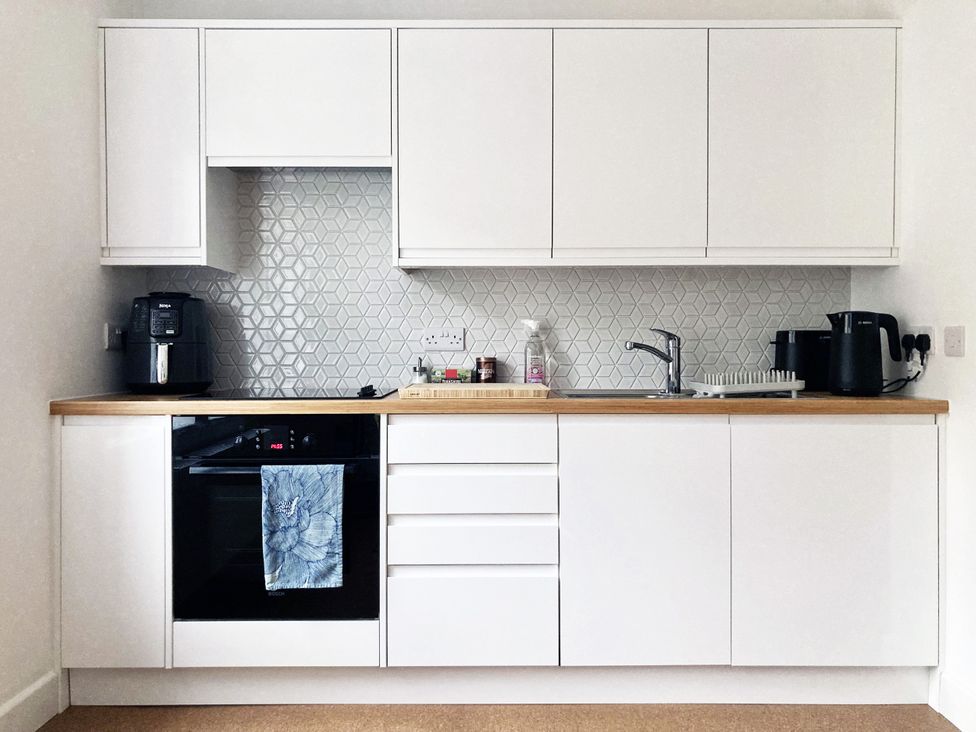 A kitchen with cabinets, sink and appliances at The Old Riverside School House Apt 5 Hebden Bridge