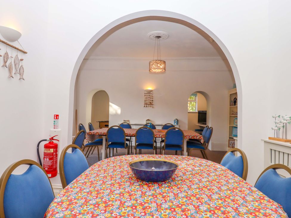 A dining room with a table and chairs at Babbacombe Hall in Babbacombe