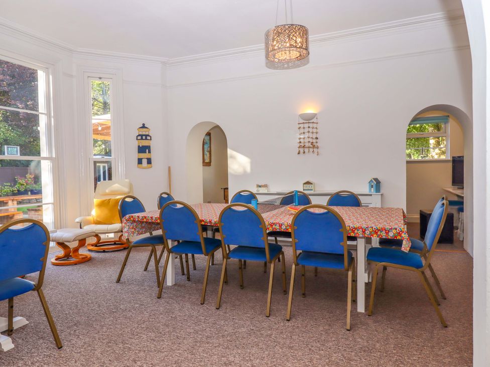 A dining room with a table and chairs at Babbacombe Hall in Babbacombe