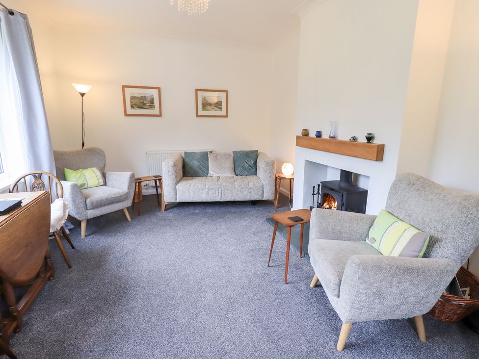 A living room with a sofa, armchairs, and a fireplace at Rock Cottage in Keswick