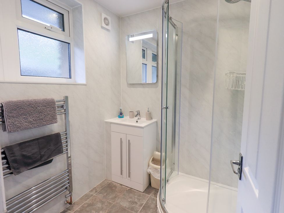 A bathroom featuring a shower, sink and towel rack at Rock Cottage in Keswick